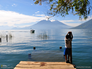 Man dock boat water mountain - the water and a mountain in the distance free wallpaper