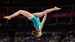 Woman handstand balance beam stadium - dynamic camera angle free wallpaper