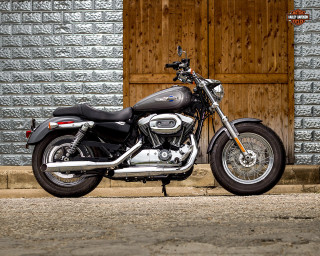 Motorcycle parked building wooden door - a brick wall behind free wallpaper