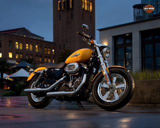 Yellow motorcycle parked building night - a clock tower in the background free wallpaper