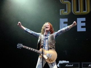 Man guitar stage arms up - kitsch movement free wallpaper