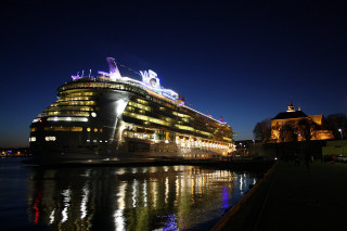 Cruise ship docked night city - side and a city in the background free wallpaper