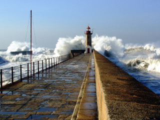 Lighthouse waves pier fence stormy - a light house in the distance free wallpaper