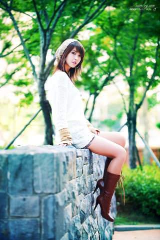 Woman sitting stone wall hat - free retro wallpaper