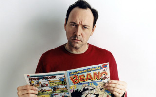 Man holding comic book frowning - a comic book free wallpaper