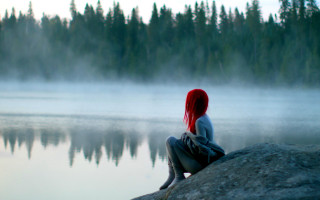 Woman sitting rock lake fog - over a lake free wallpaper