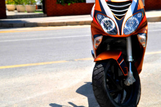 Motorcycle parked side road building - front view free wallpaper