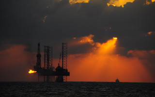 Oil rig water cloudy sunset 2 - a large body of water under a cloudy sky free wallpaper