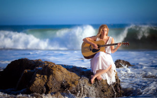 Woman sitting rock playing guitar - a wave free wallpaper