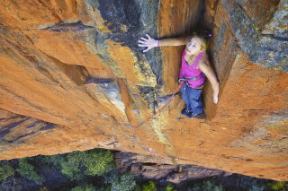 Woman climbing cliff arms out - kodachrome free wallpaper
