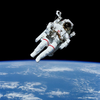 Astronaut floating above earth space - free space wallpaper for tablet