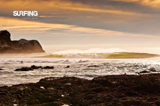 Surfer wave rocky shore cityscape - a surfer free wallpaper