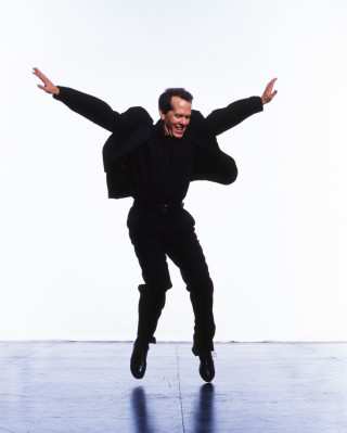 Man jumping black suit outstretched - his hands out free wallpaper for mobile