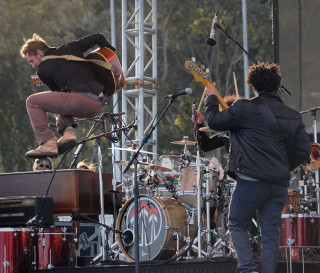 Man jumping guitar stage performance - action free wallpaper for desktop