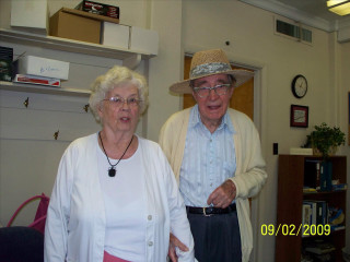 Man woman standing room clock - the wall behind them free wallpaper