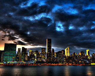 City skyline dark sky clouds 5 - a boat in the foreground free wallpaper