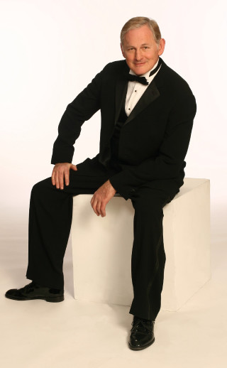 Man tuxedo sitting white block - studio portrait free wallpaper