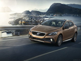 Brown volvo car road water - a city in the distance free wallpaper