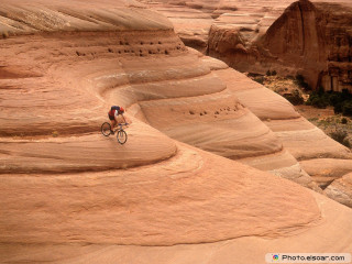 Man riding bike desert cliff - a desert landscape free wallpaper