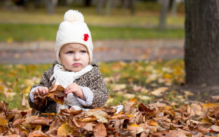 Little girl sitting leaves park - her shoulder free wallpaper