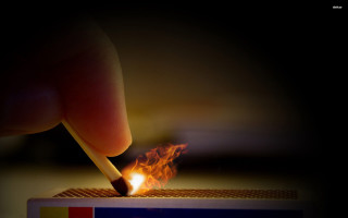 Person lighting match flame sparks - fire in the background free wallpaper