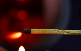 Matchstick lit candle red background - a matchstick free wallpaper