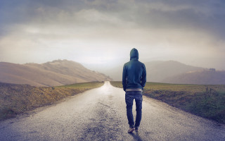 Man walking road mountain range - a hoodie free wallpaper