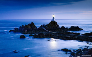 Lighthouse rocky shore night full 2 - radiant light free wallpaper
