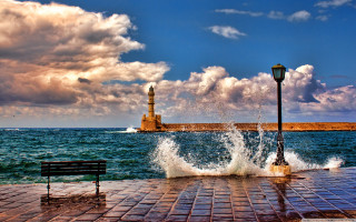 Lighthouse ocean bench brickwalkway stormy - a light house in the distance free wallpaper