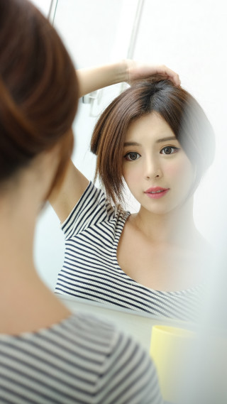 Woman looking mirror holding hair - the mirror free wallpaper for mobile