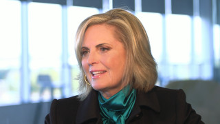 Blonde woman black jacket green - a window behind her free wallpaper