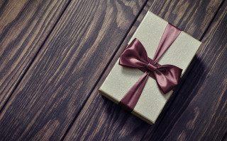 Wrapped gift red bow wooden - a wooden background free wallpaper