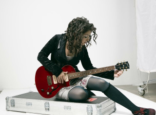 Woman sitting suitcase playing guitar - a guitar free wallpaper