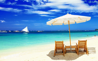 Beach chairs umbrella boats sailboat - the water behind them free wallpaper