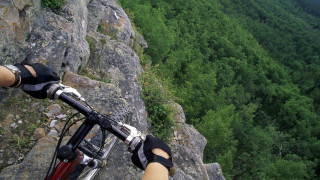 Person riding bike rocky trail - dynamic camera angle free wallpaper
