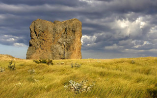 Large rock grassy field cloudy - a large rock free wallpaper