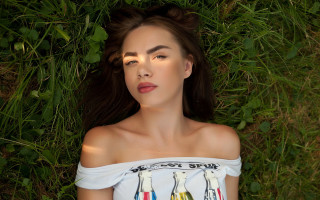 Woman laying on grass blowing - sun free wallpaper for desktop