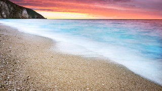 Beach wave cliff pink sky - blue water free wallpaper