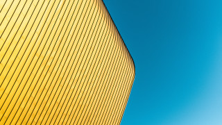 Yellow building blue sky plane - a plane in the foreground free wallpaper for desktop