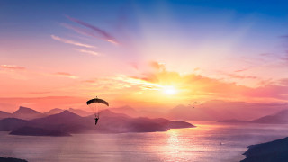Parasailer mountain sunset water sky - over a mountain range free wallpaper