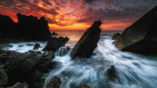 Sunset rocky beach waves red - against the rock free wallpaper