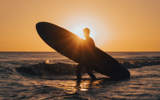 Man surfboard ocean sunset shining - the sun shining behind free wallpaper