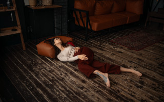 Woman laying livingroom brownchair redrug - a red rug free wallpaper