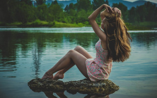 Woman sitting on rock beach - flowing free wallpaper