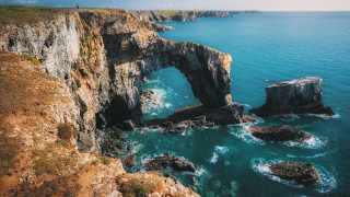 Ocean rock formation person stand - free landscape wallpaper