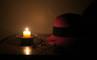 Hat glasses candle stilllife dark - a table in the dark free wallpaper