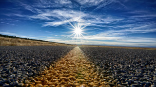 Road rocks sky sunset ocean - a bright sun in the sky above free wallpaper
