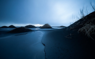 Dark cloudy beach rocks grass - a dark free wallpaper