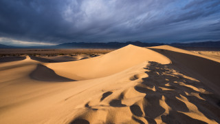 Desert sand dune cloudy sky - a large sand dune free wallpaper