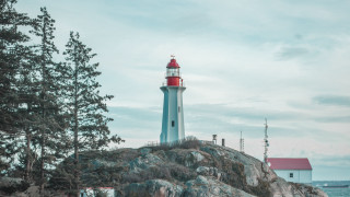Lighthouse rocky outcropping red roof - free winter wallpaper